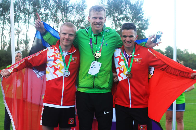 Corrin Leeming (left) and Alan Corlett (right) on the 10,000m podium with their silver and bronze medals