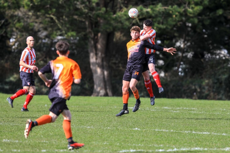 Ayre United attacker Shaun Kelly (left) challenges Peel's Sam Kennaugh to a header during last weekend's FA Cup semi-final. Kelly will be hoping to help the Tangerines lift the trophy against Rushen United this Saturday (Photo: Callum Staley)