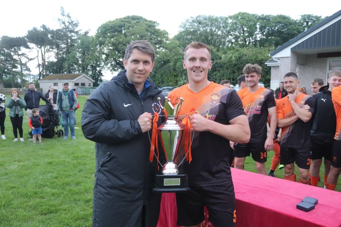 Ayre United captain Jamie Callister receives the Canada Life Premier League trophy from Isle of Man Football Association's interim chief executive officer Lewis Qualtrough