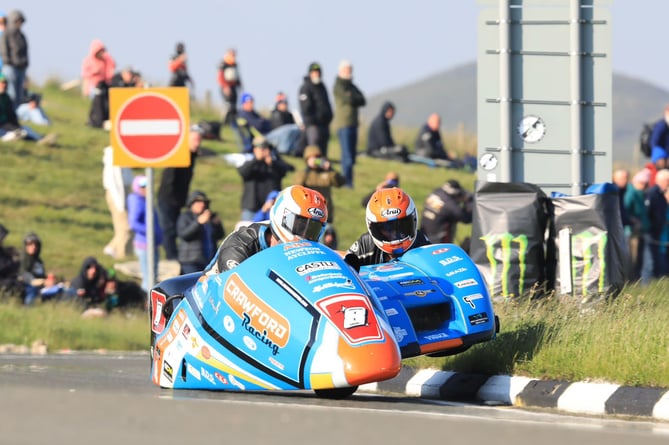 Lee Crawford and Scott Hardie clipping the grass at the Bungalow during the opening lap of the Sidecar Race One