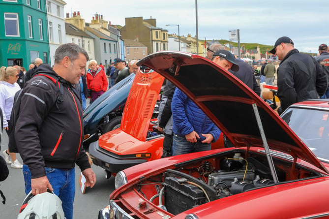 Visitors to Peel TT Day admire the classic cars on show