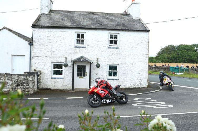 Local newcomer Grant Thomson leads Bradford's Adrian Harrison past the cottages at Cross Four Ways in the 600cc B race on Thursday morning (Photo: Dave Kneen/www.ManxPhotosOnline.com)