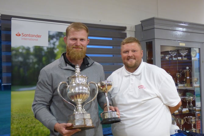 Seth Waterworth (left) receives the impressive Peel Town Cup from Callum Burke of competition sponsor Santander International