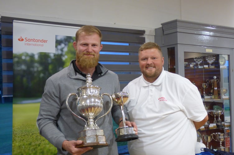 Seth Waterworth (left) receives the impressive Peel Town Cup from Callum Burke of competition sponsor Santander International