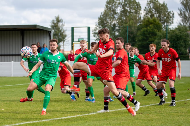 FC Isle of Man's Jacob Crook (centre) challenges a Charnock Richard opponent for the ball during Saturday's clash in Chorley, Lancashire (Photo: Steven Taylor/SJT Photos)