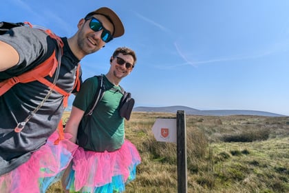 Friends walk the length of the island with their legs tied together