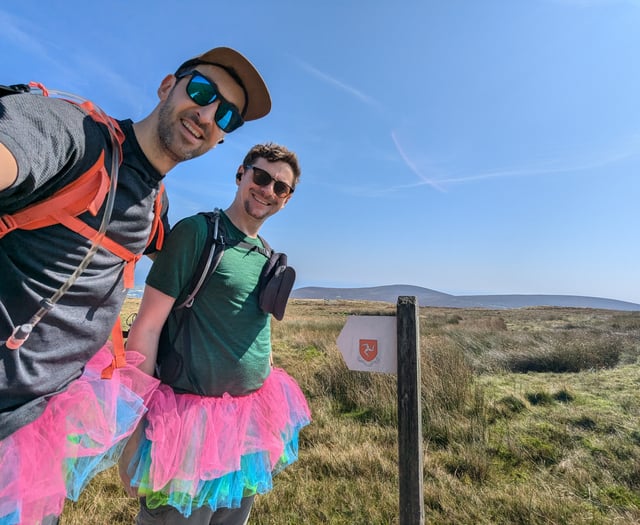 Friends walk the length of the island with their legs tied together