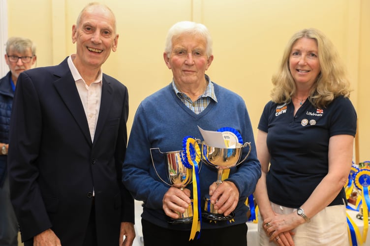 Stuart Lambie (Foxdale Heritage Centre) & Helen Dickinson (Peel RNLI) presenting Jim Caine with the T Ffinlo Corkill Trophy for best exhibit in the vegetables section & Betty Holgate Memorial Cup for the best carrot. 