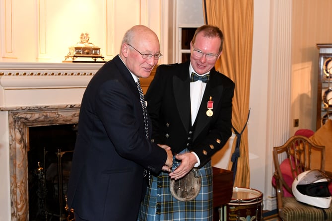 Sir John Lorimer awards Milky Quayle with a British Empire Medal