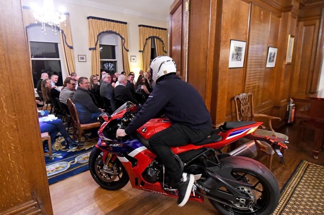 John McGuiness MBE rides in to Government House on a motorbike