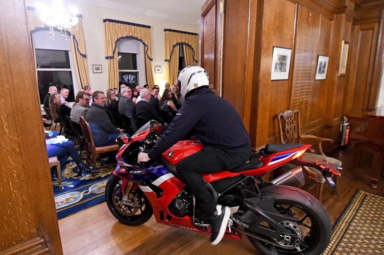 John McGuiness MBE rides in to Government House on a motorbike