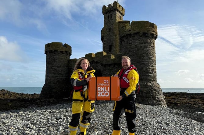 Douglas RNLI volunteer Coxswain, Emily Heaton and Port Erin Mechanic Jason Fleming with the scroll at the Tower of Refuge