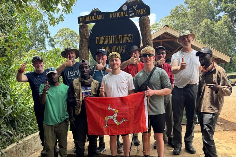 Friends and family of Lucas Martin holding the Isle of Man flag aloft ahead of their 27 mile trek, climbing 5895m, and braving freezing temperatures of -15°C at only 50% oxygen