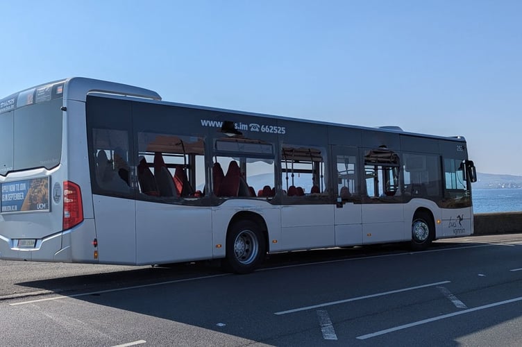 The side of a single-decker bus with several smashed windows